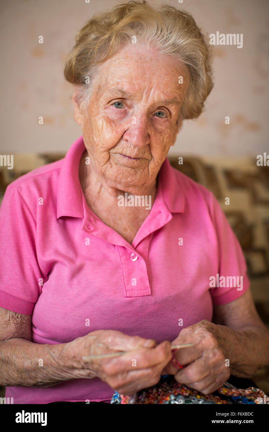 Vieille Femme assise et le tricotage. Grand-mère. Banque D'Images