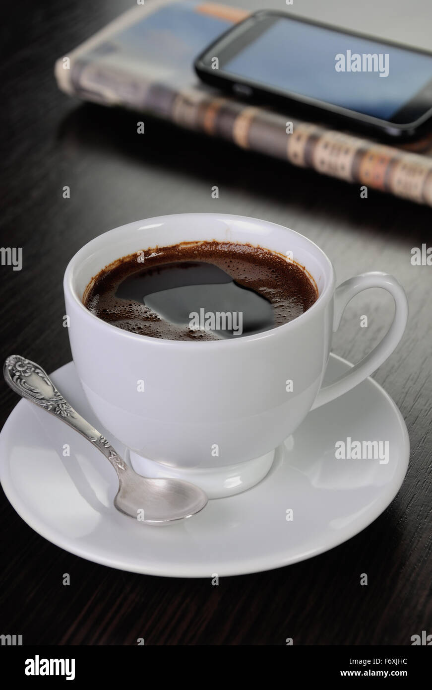 Tasse de café sur la table avec du papier journal et smartphone Banque D'Images