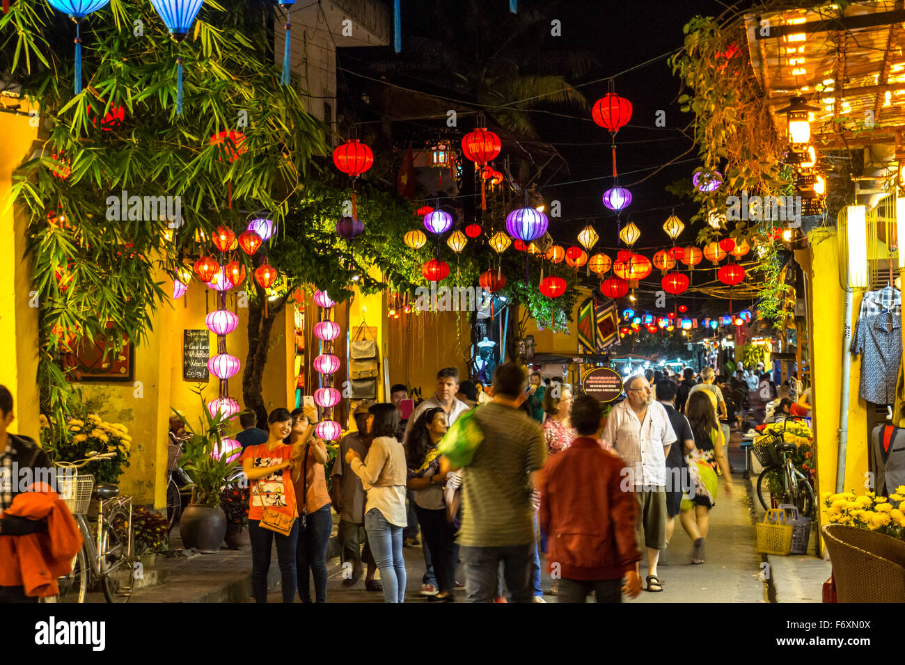 HOI AN, VIETNAM - 26 février 2015 : Lampions lumineuse suspendue au-dessus de la rue de marche de la vieille ville de Hoi An dans la nuit avec de nombreux touristes autour là. Banque D'Images