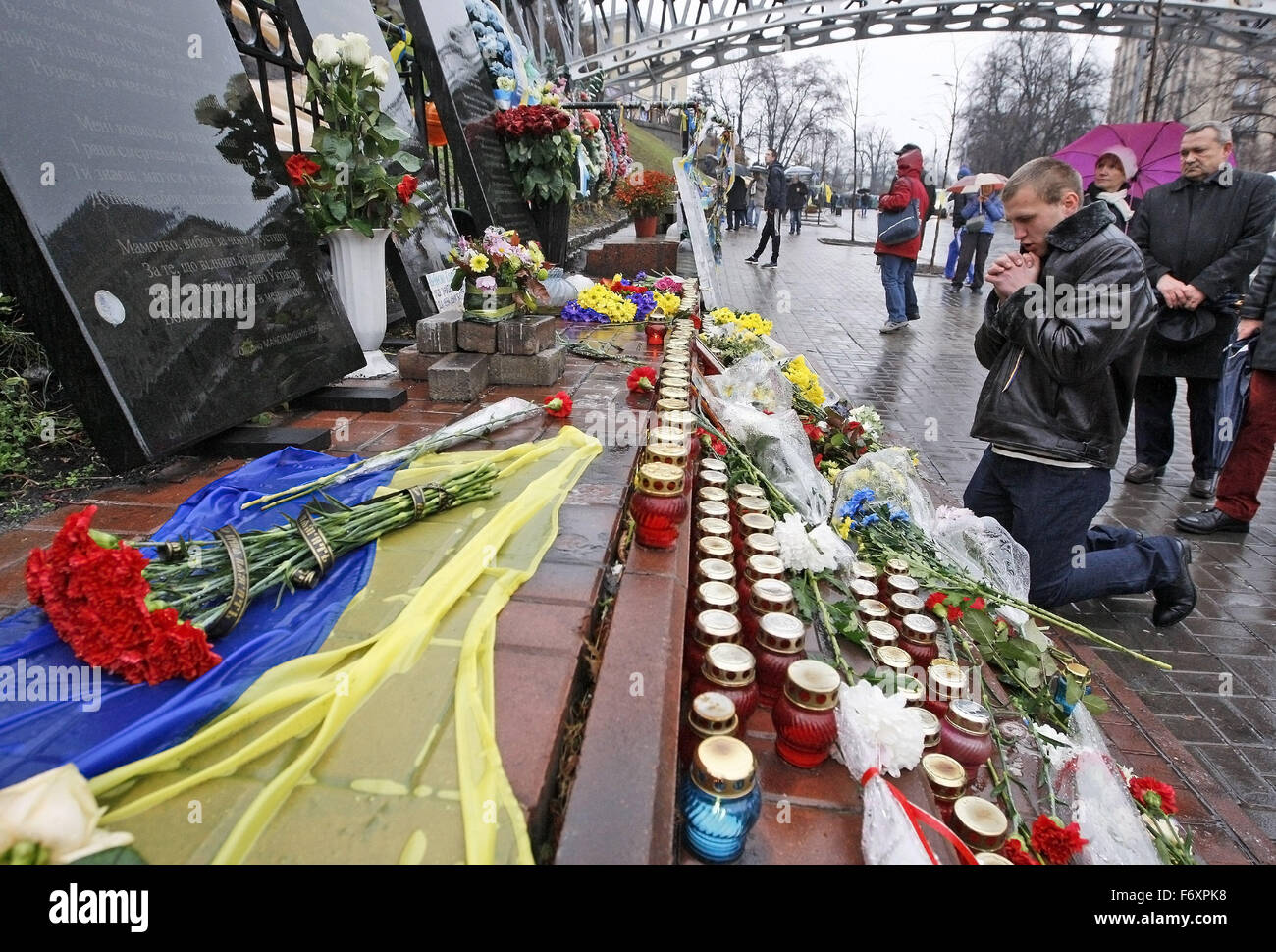 Kiev, Ukraine. 21 Nov, 2015. Un homme prier devant le mémorial aux victimes de manifestations anti-gouvernementales sur Maidan dans la rue Institutska, pendant le deuxième anniversaire de la révolution d'Euromaidan à Kiev, Ukraine, le 21 novembre 2015. Le 21 novembre 2013 a commencé des militants une manifestation de protestation contre le gouvernement après le premier ministre Mykola Azarov a annoncé la suspension d'un traité historique avec l'Union européenne. La suite mené à la destitution du Président Viktor Ianoukovitch, la création de clivages politiques à travers le pays qui ont éclaté dans les conflits violents entre les séparatistes et les forces gouvernementales Banque D'Images