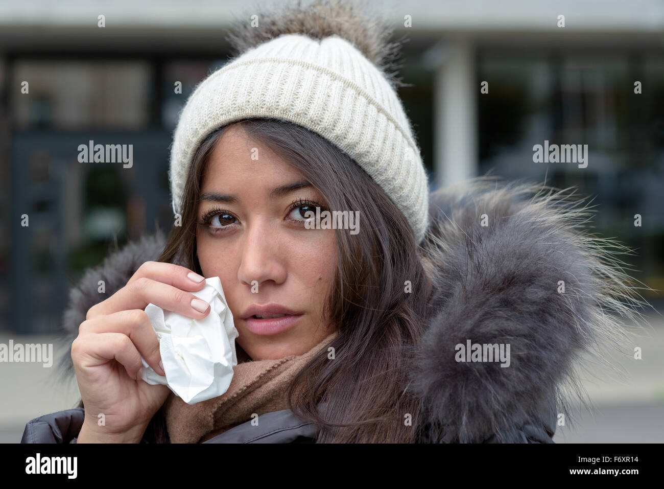 Femme en larmes triste mode hiver chaud en tenant un mouchoir à son visage pour sécher les larmes de ses yeux à la recherche dans le s Banque D'Images