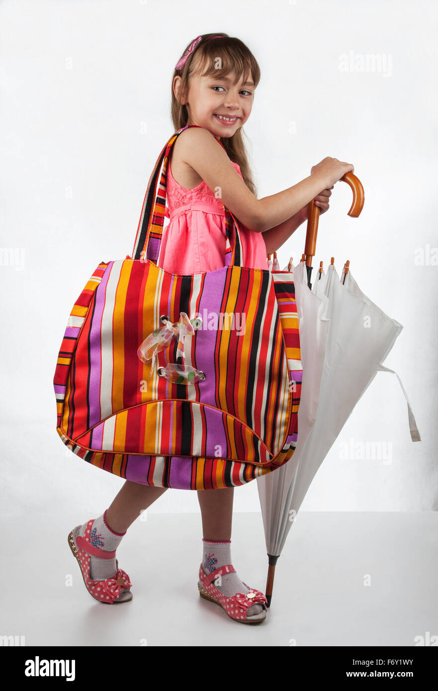 Petite fille avec un sac et parapluie Banque D'Images