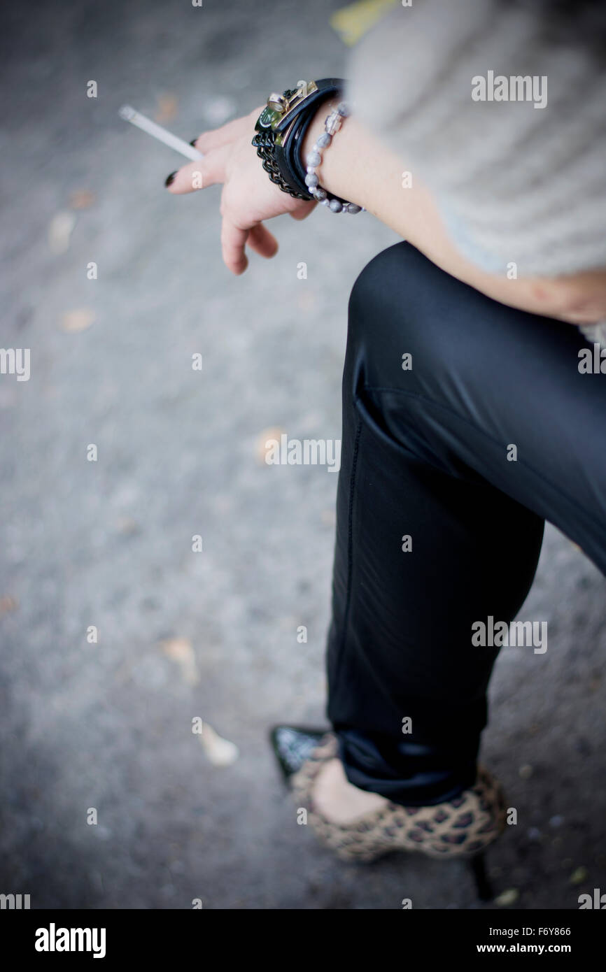 Belle black hair woman enjoying cigarette dans park Banque D'Images