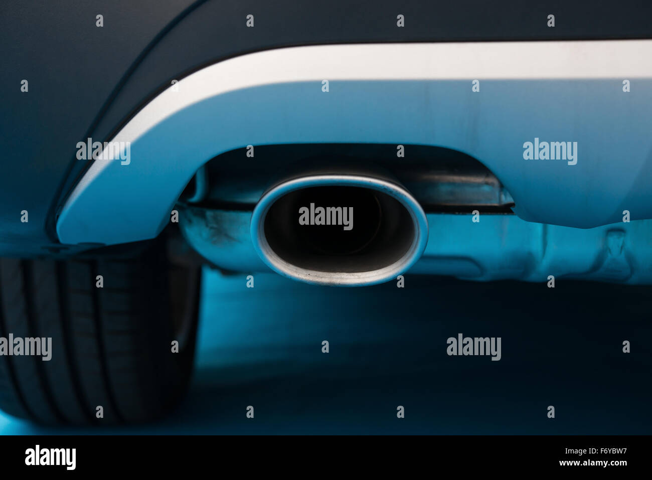 Tuyau d'échappement d'une voiture noire sur tapis bleu Banque D'Images