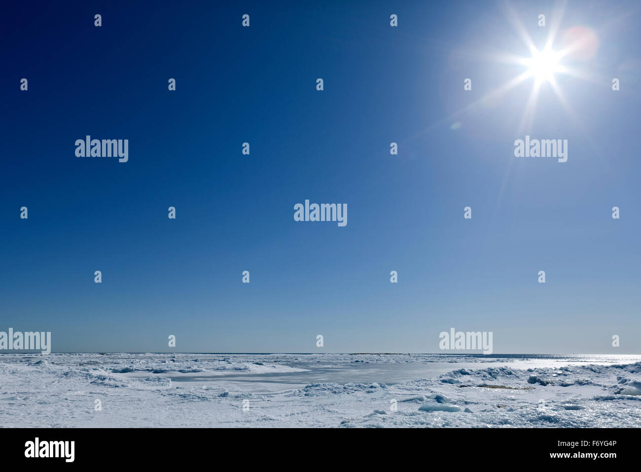 Un soleil brillant au-dessus de la mer gelée. La glace rugueuse sur la mer, certains dérivé de la glace et de la neige. Avril sur la mer Baltique. Banque D'Images