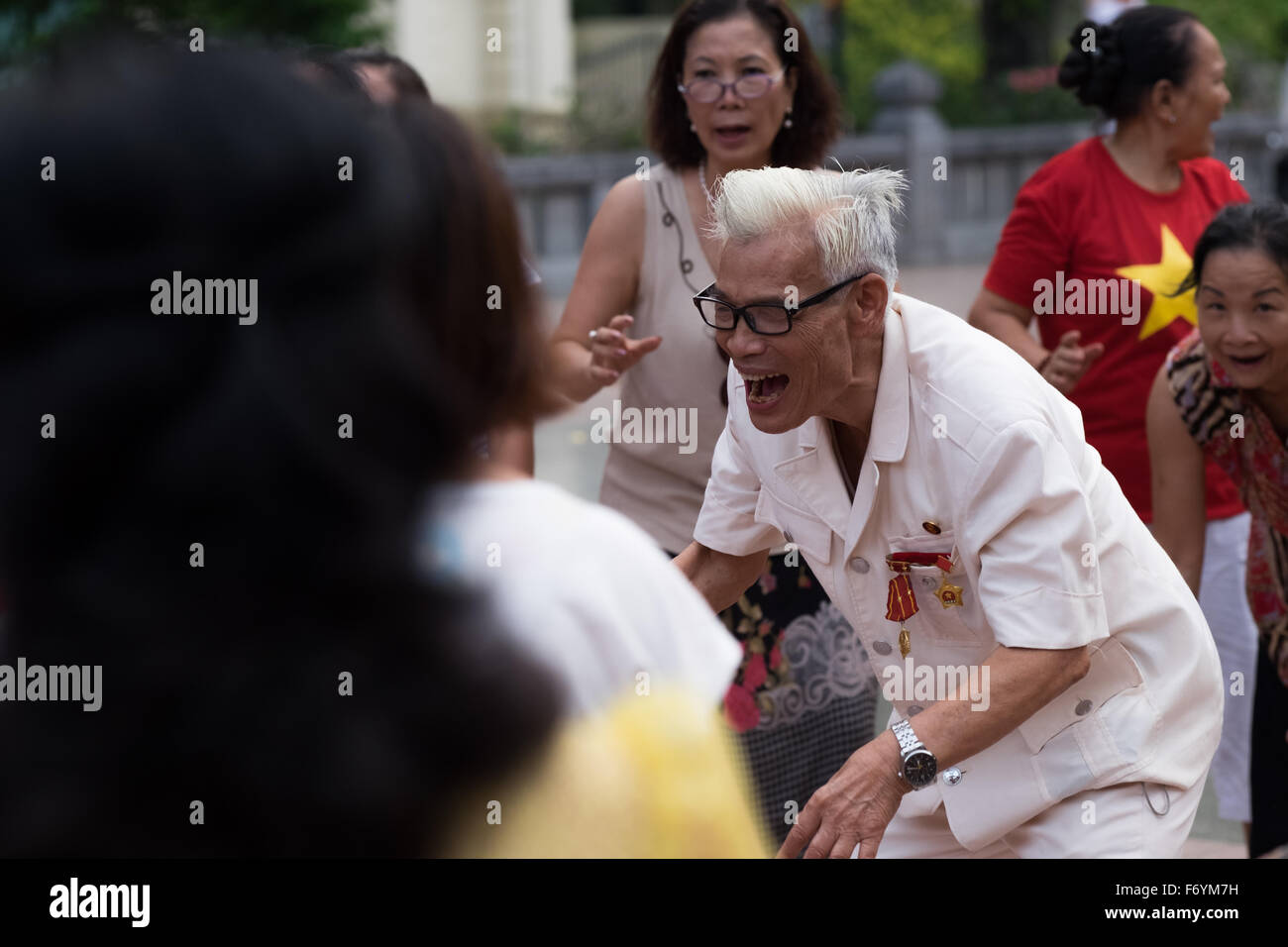 Les membres du Club de yoga du rire de Hanoi recueillir tôt chaque matin à l'Ly Thai To monument situé près du lac Hoan Kiem Banque D'Images