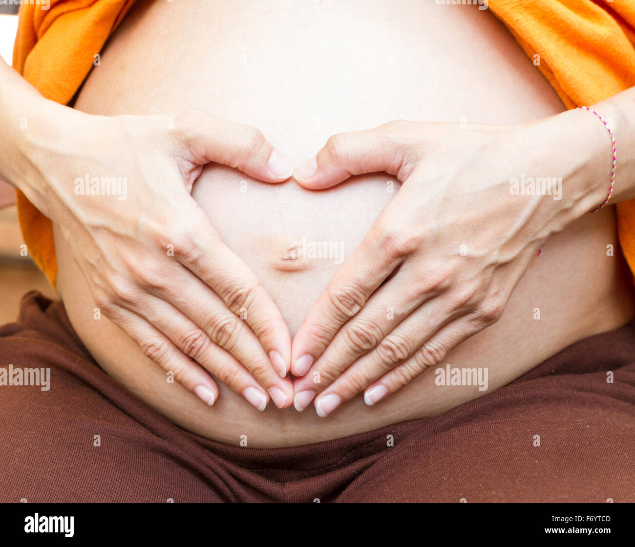 La maternité maternité concept.pregnant woman holding ses mains en forme de coeur sur son bébé. Pregnant Belly avec les doigts Banque D'Images