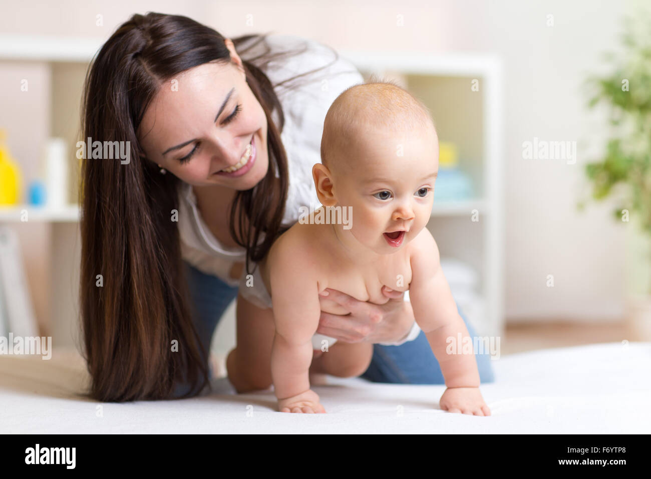 Funny baby crawling with mother Banque D'Images