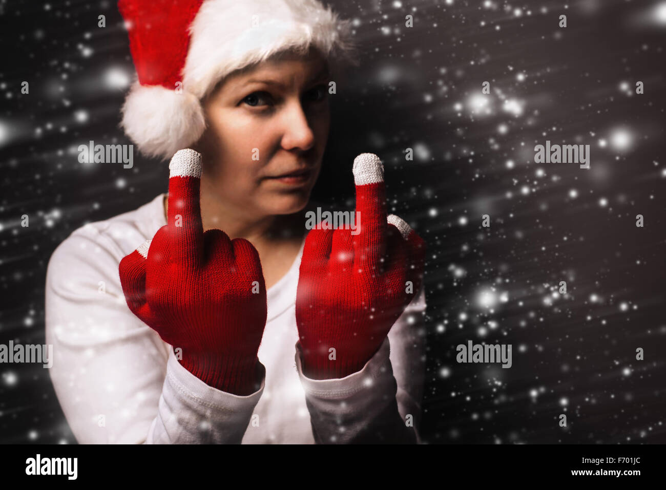 Cadeau de Noël est en retard cette année, young adult woman in santa claus costume montrant doigt moyen, selective focus. Banque D'Images