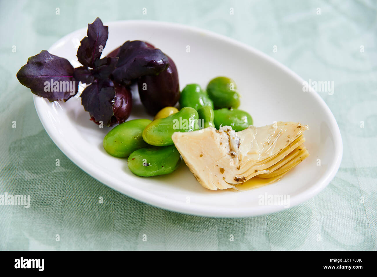 Les fèves avec les coeurs d'artichauts marinés et olives Banque D'Images
