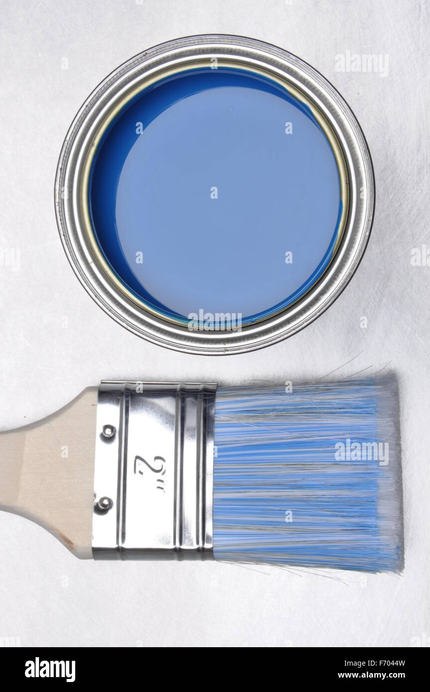 Vue de dessus de la peinture bleu peut à l'aide d'un pinceau sur fond métal gris Banque D'Images