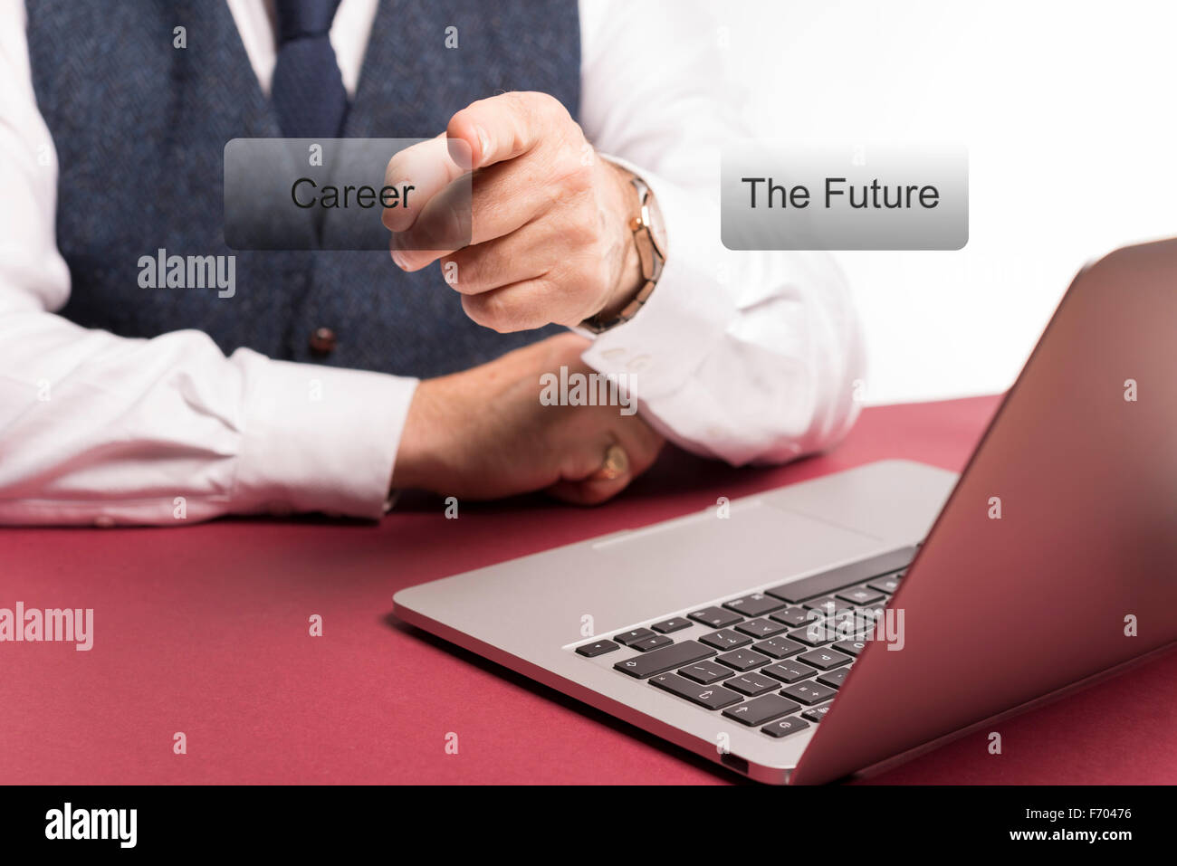Smartly dressed businessman sitting at desk with laptop en vue pointant sur le mot carrière sur un écran clair Banque D'Images