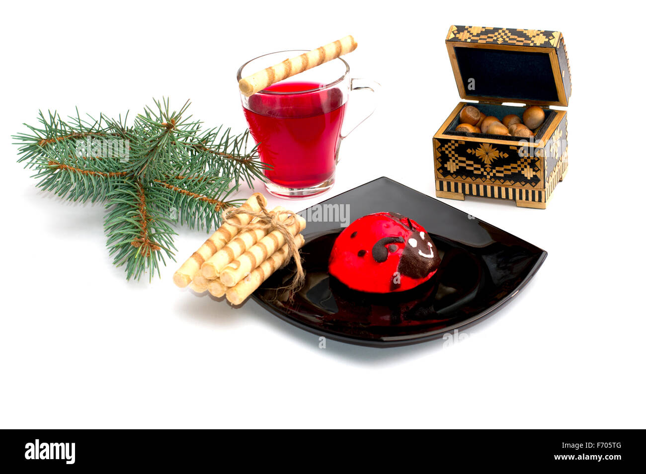 Plaque avec gâteau rouge, thé, et une direction générale des nucules de conifères, une nature morte, l'objet Noël et Nouvel An Banque D'Images