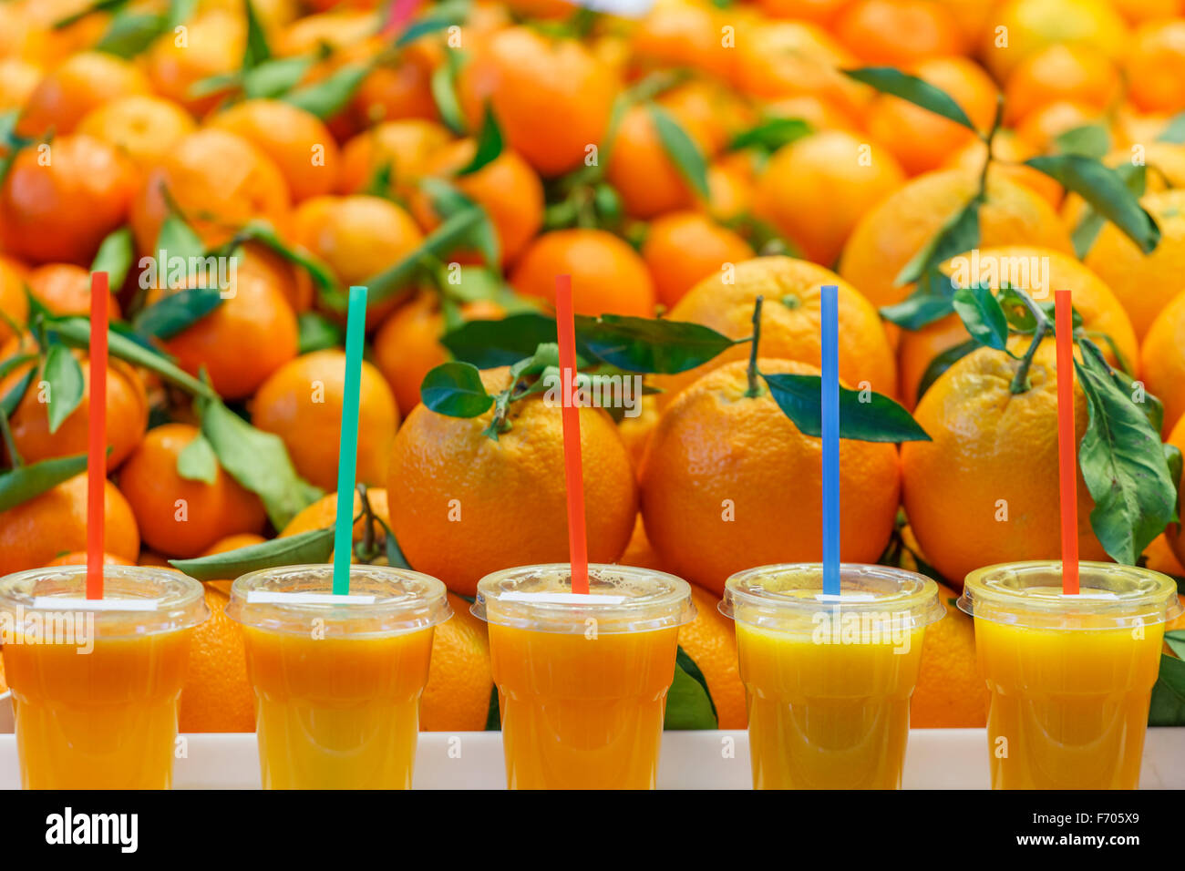 Le jus d'Orange fruit smoothies en face d'un tas d'oranges fraîches Banque D'Images