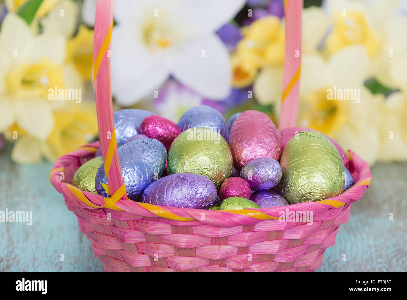 Couleur pastel des œufs en chocolat dans un panier de Pâques rose Banque D'Images