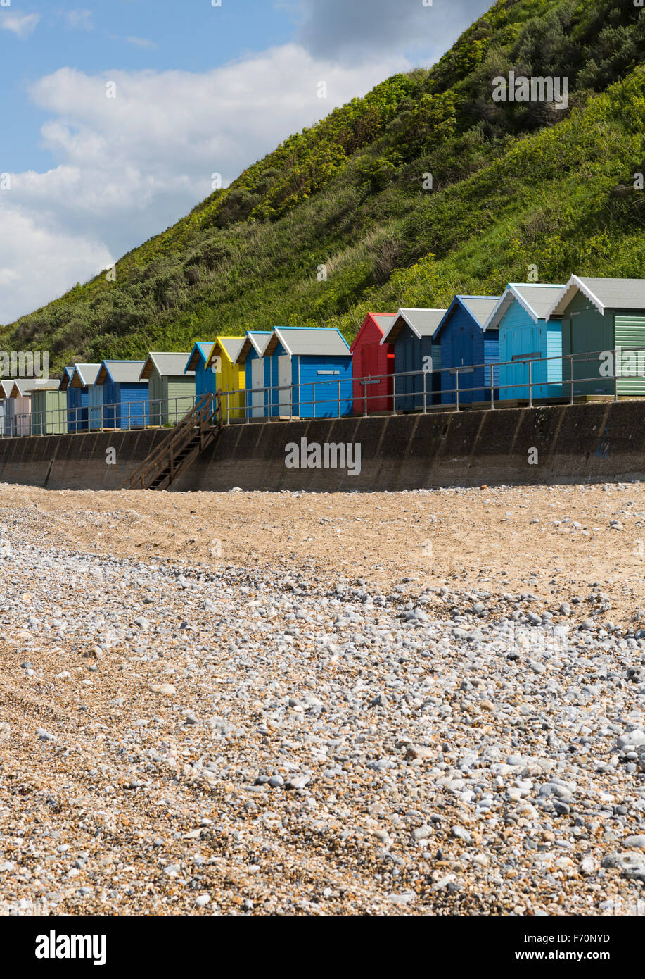 Cabines de plage en face des falaises à Cromer, Norfolk, UK, journée ensoleillée avec ciel bleu et nuages en orientation portrait. Non aiguisé Banque D'Images