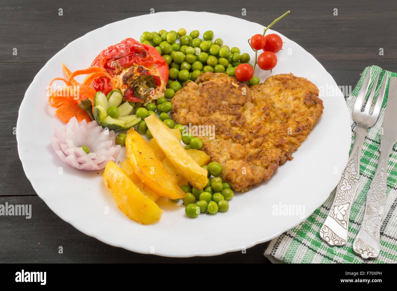 Steak avec pommes de terre en forme de coeur, les tomates cerises et les haricots verts sur une plaque Banque D'Images