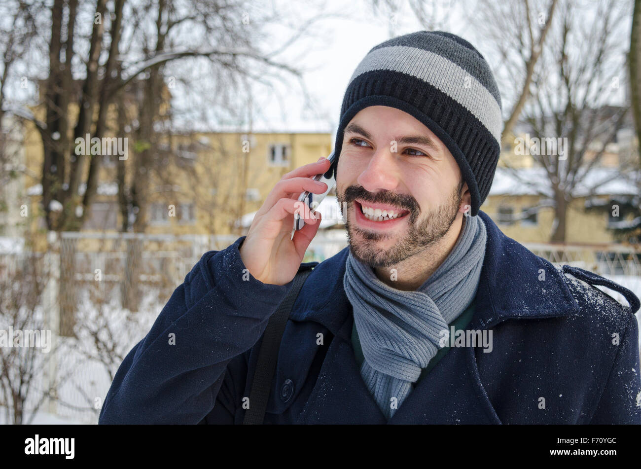 Bearded man talking on a cell phone en hiver Banque D'Images