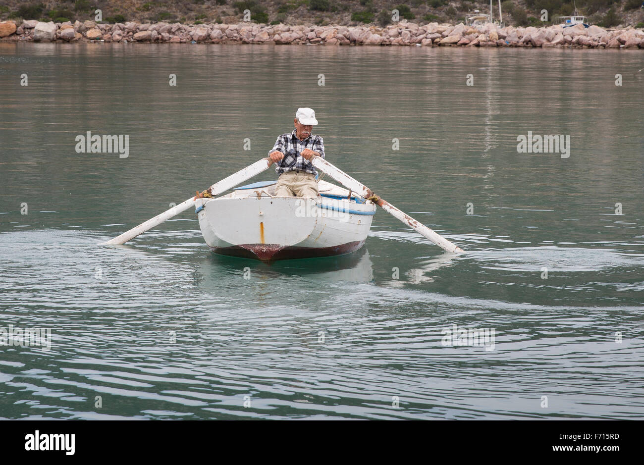 Aviron pêcheur grec son bateau de la Harbour à Ermioni, Grèce et dans la mer Égée Banque D'Images