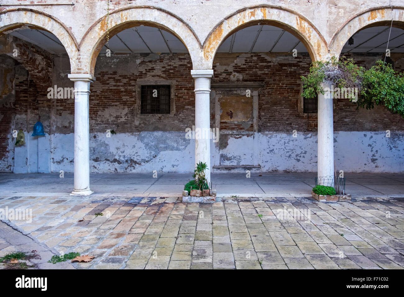 Venise. Cour du cloître de la basilique San Pietro di Castello encadrées par des arches et un passage couvert Banque D'Images Venise. Cour du cloître de la basilique San Pietro di Castello encadrées par des arches et un passage couvert Banque D'Images