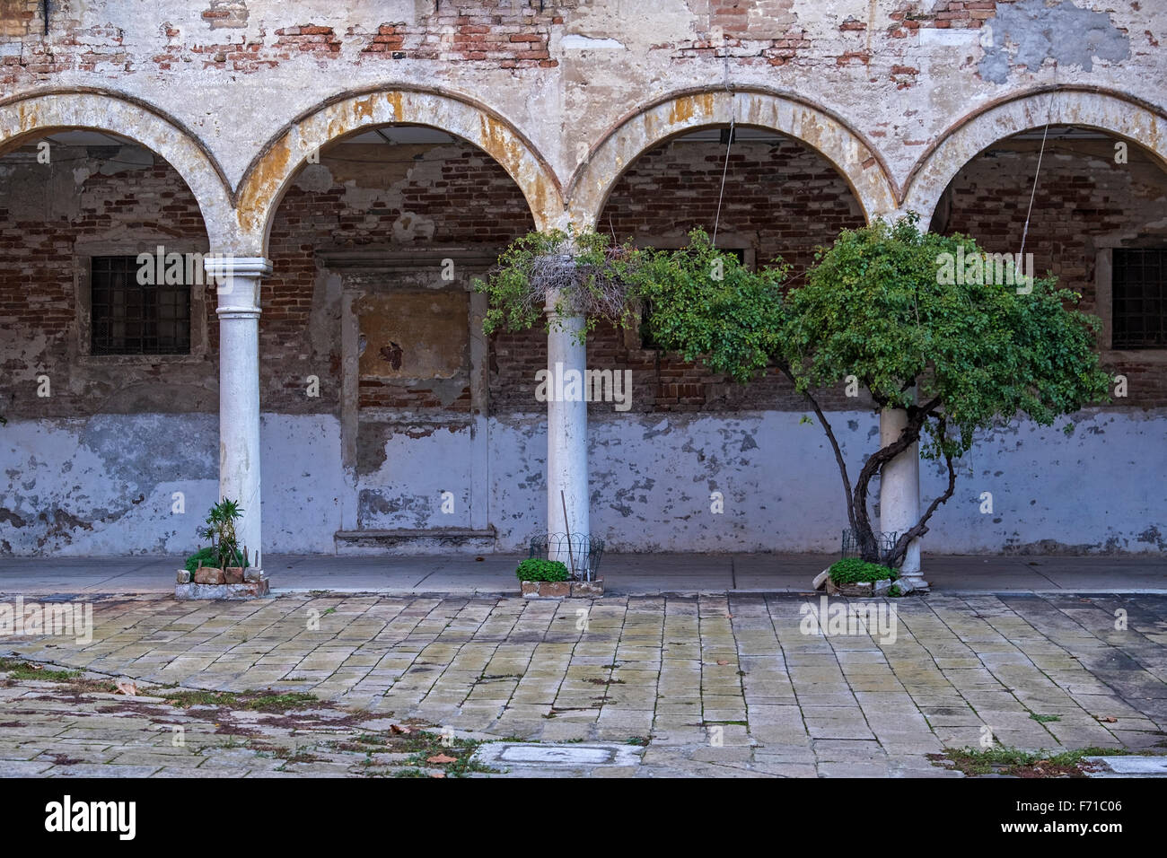 Venise. Cour du cloître de la basilique San Pietro di Castello encadrées par des arches et un passage couvert Banque D'Images