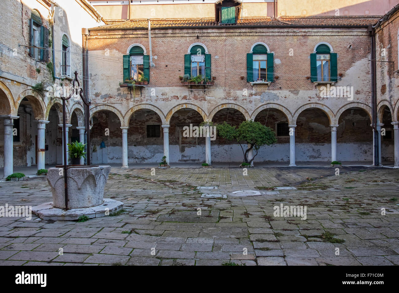 Venise. Cour du cloître de la basilique San Pietro di Castello encadrées par des arches et un passage couvert Banque D'Images Venise. Cour du cloître de la basilique San Pietro di Castello encadrées par des arches et un passage couvert Banque D'Images