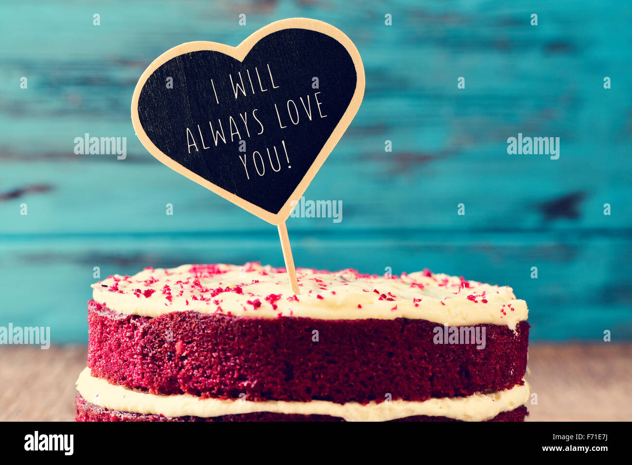 Libre de Red Velvet Cake surmonté d'un tableau noir en forme de cœur avec le texte, je vous aimerai toujours écrit en C, sur une rouille Banque D'Images