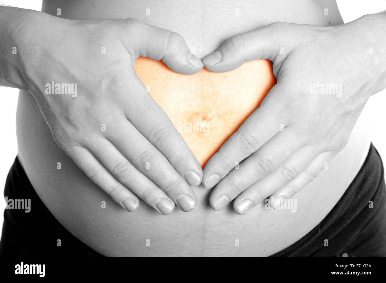 Les bras sur le ventre de maman enceinte en forme de coeur au ventre de bébé d'amour fond blanc Banque D'Images
