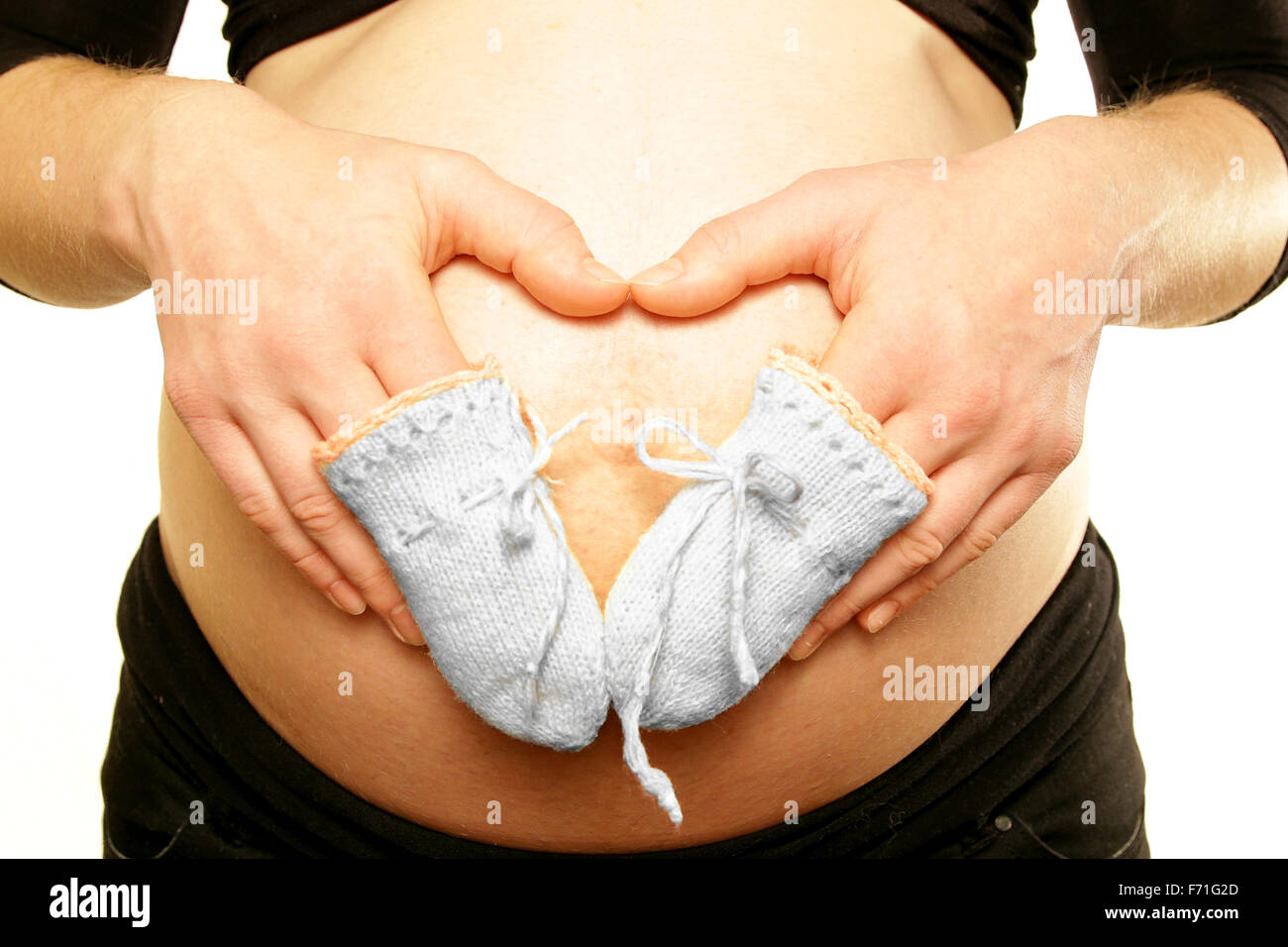 Les Bras Sur Le Ventre Du Ventre De Maman Enceinte Holding Tiny Little Mitaines En Laine Pour Bebe D Amour Fond Blanc Photo Stock Alamy