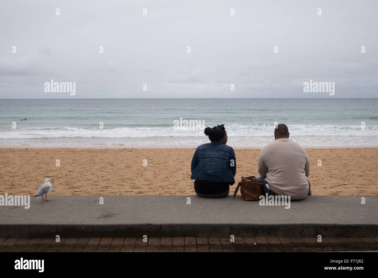 Black couple sitting beach Banque D'Images