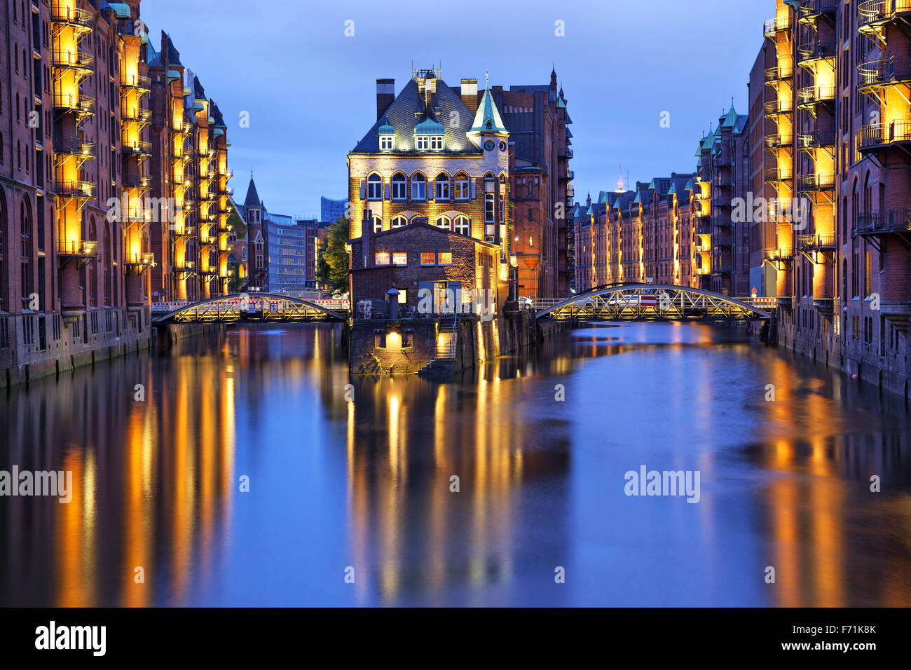 Chambre et deux jeunes mariées éclairés en soirée dans le vieux quartier des entrepôts (Speicherstadt), Hambourg, Allemagne Banque D'Images