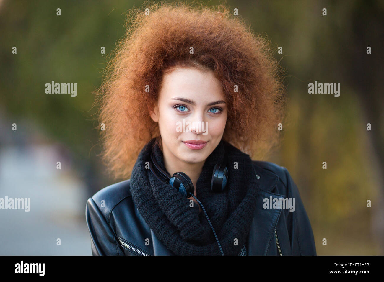Closeup portrait d'une jeune femme séduisante avec des cheveux bouclés à l'extérieur looking at camera Banque D'Images