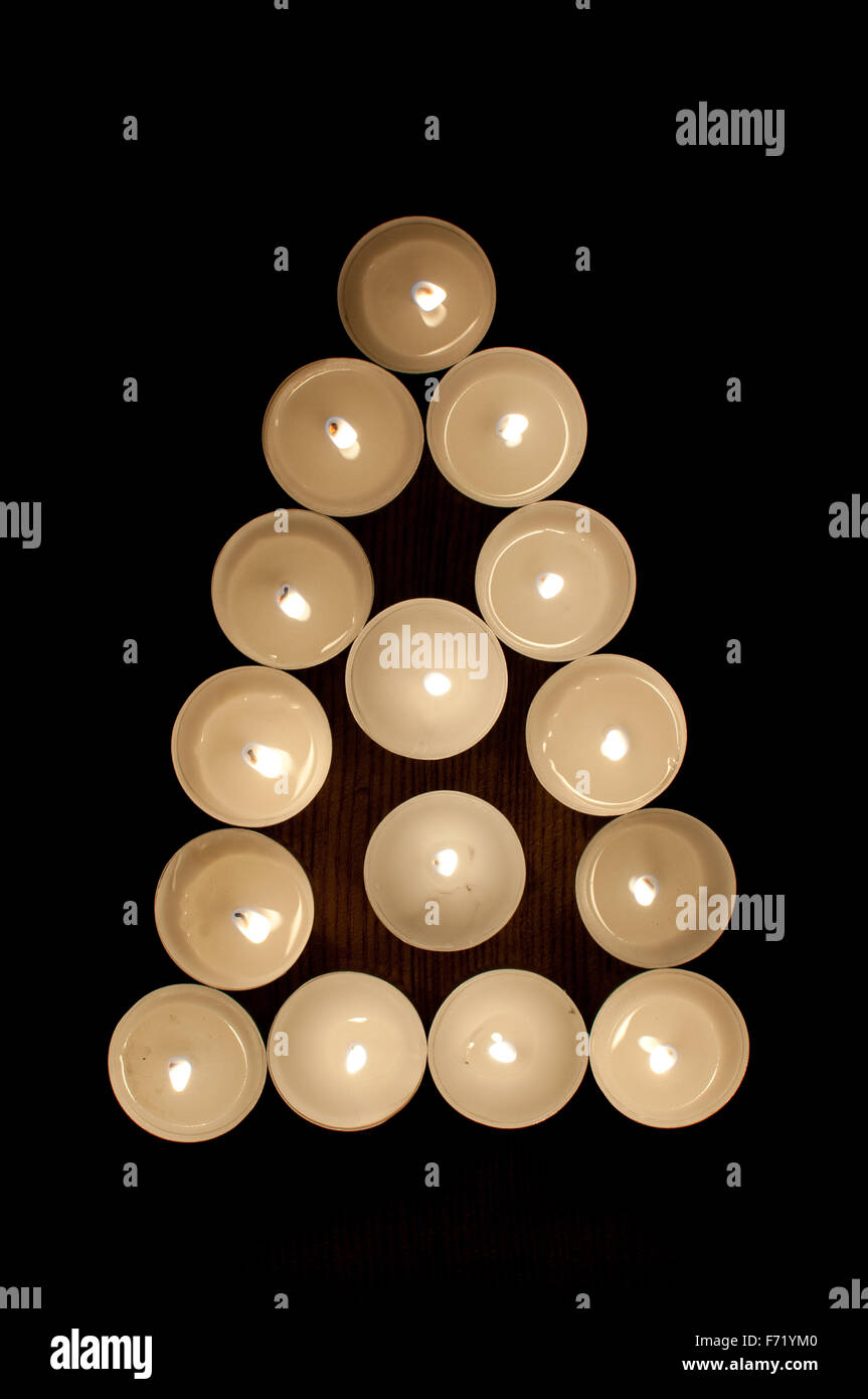 Lumières de thé disposées en forme de triangle et un arbre Banque D'Images