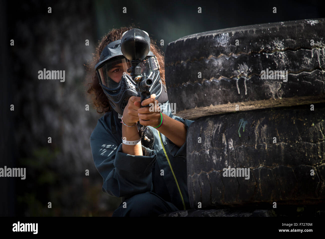 Une photographie d'un joueur de paintball girl au travail. Portrait d'une jeune joueuse de paintball en action. Banque D'Images