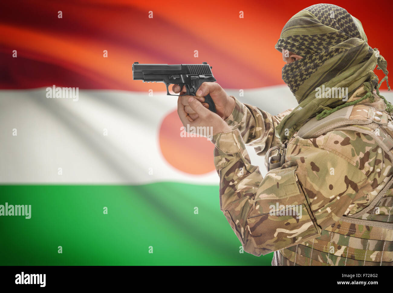Mâle en keffieh musulmane avec fusil à la main et drapeau national sur fond de série - Niger Banque D'Images