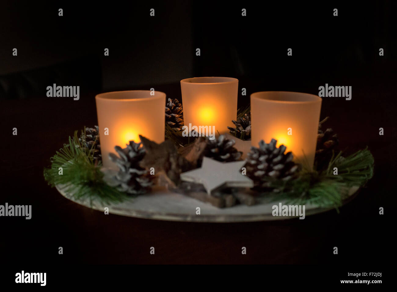 Nouvelle année (Noël) décoration avec trois bougies allumées, les étoiles, les glands, Banque D'Images