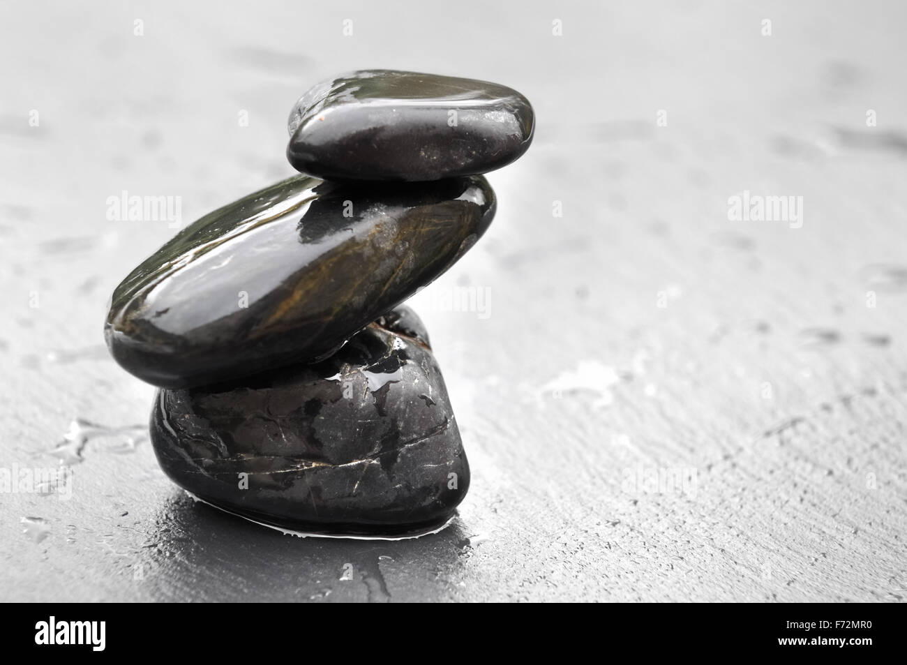 Les pierres noires humides sur l'équilibre sur fond d'ardoise Banque D'Images