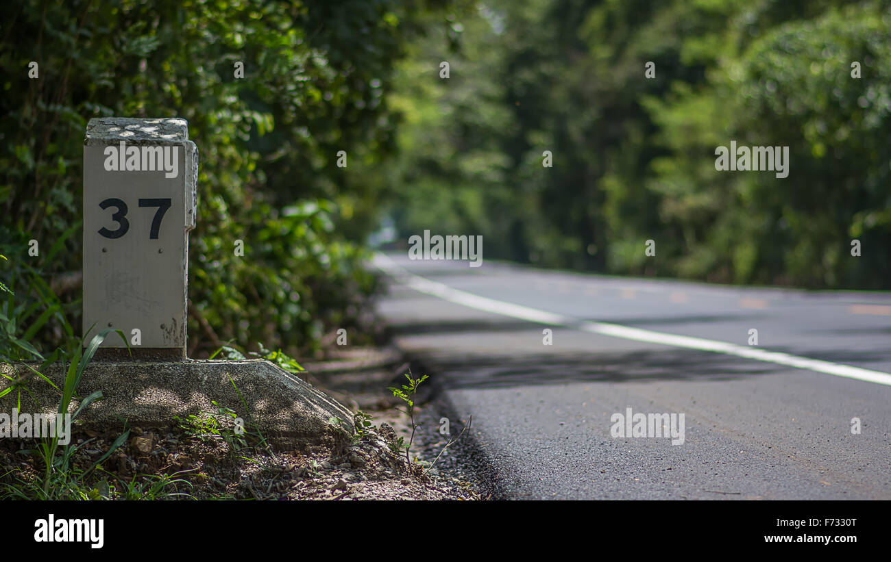 Un poste par le côté d'une route qui indique la distance en kilomètre ou milepost pierre pour un lieu déterminé Banque D'Images