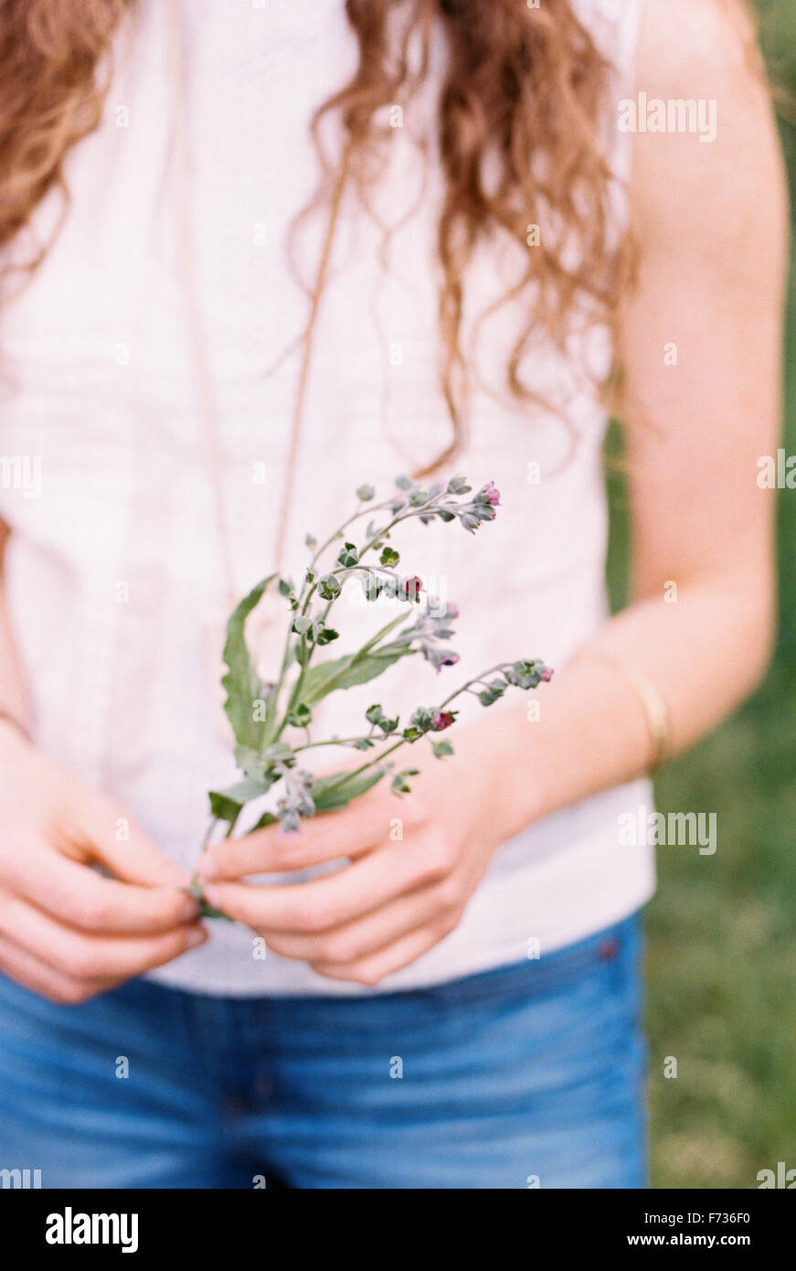 Portrait d'une femme tenant une fleur sauvage. Banque D'Images