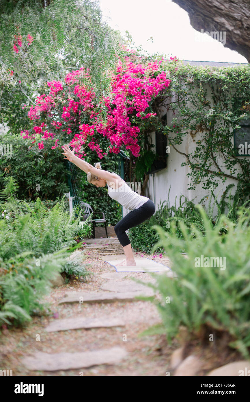 Blonde woman doing yoga dans un jardin. Banque D'Images