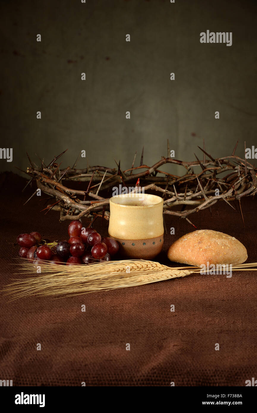Table avec coupe de vin, pain, raisins, blé, et couronne d'épines Banque D'Images