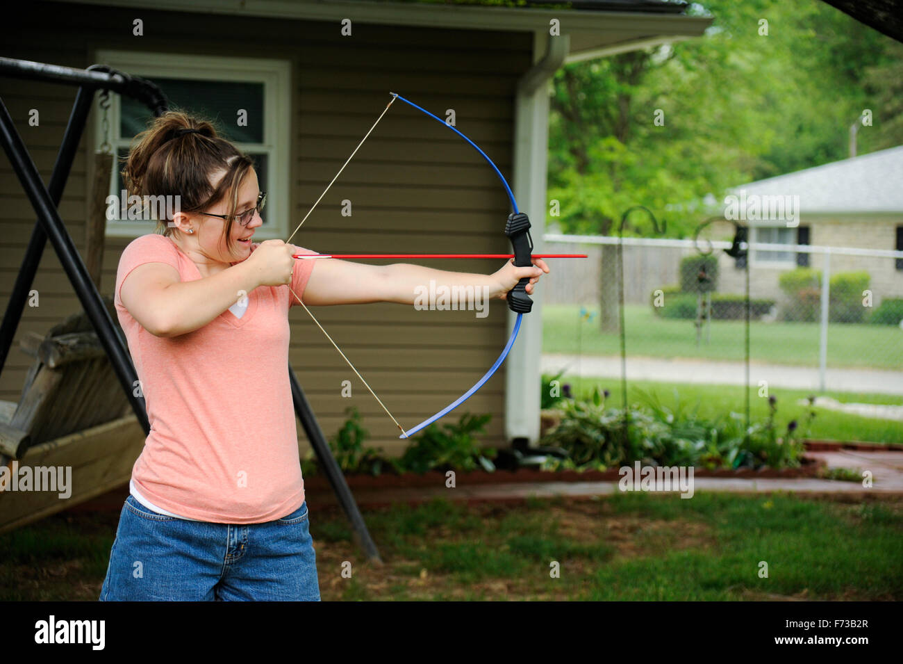 Pré-ado fille avec arc et flèche en arrière-cour Banque D'Images