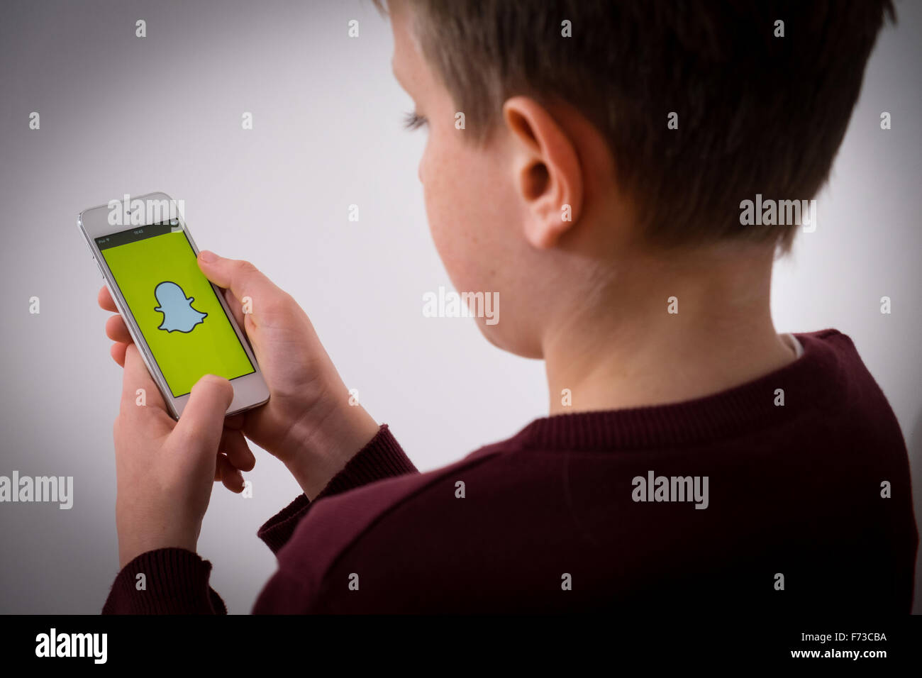 Un garçon en utilisant l'application Snapchat Banque D'Images