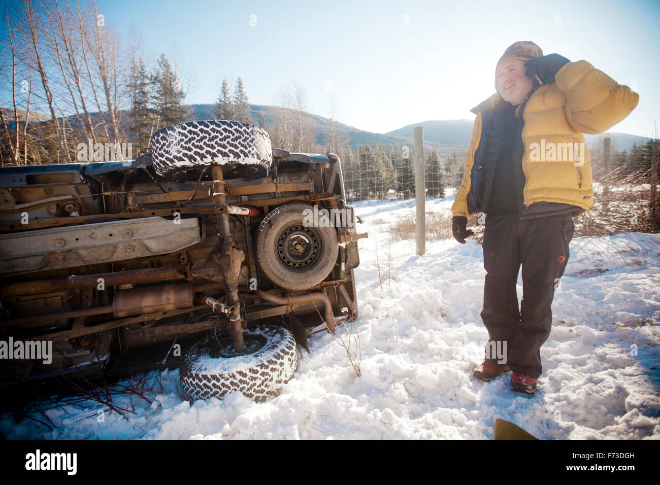 Un homme utilise son téléphone cellulaire pour demander de l'aide après un accident de camion sur l'autoroute de Coquihalla Banque D'Images