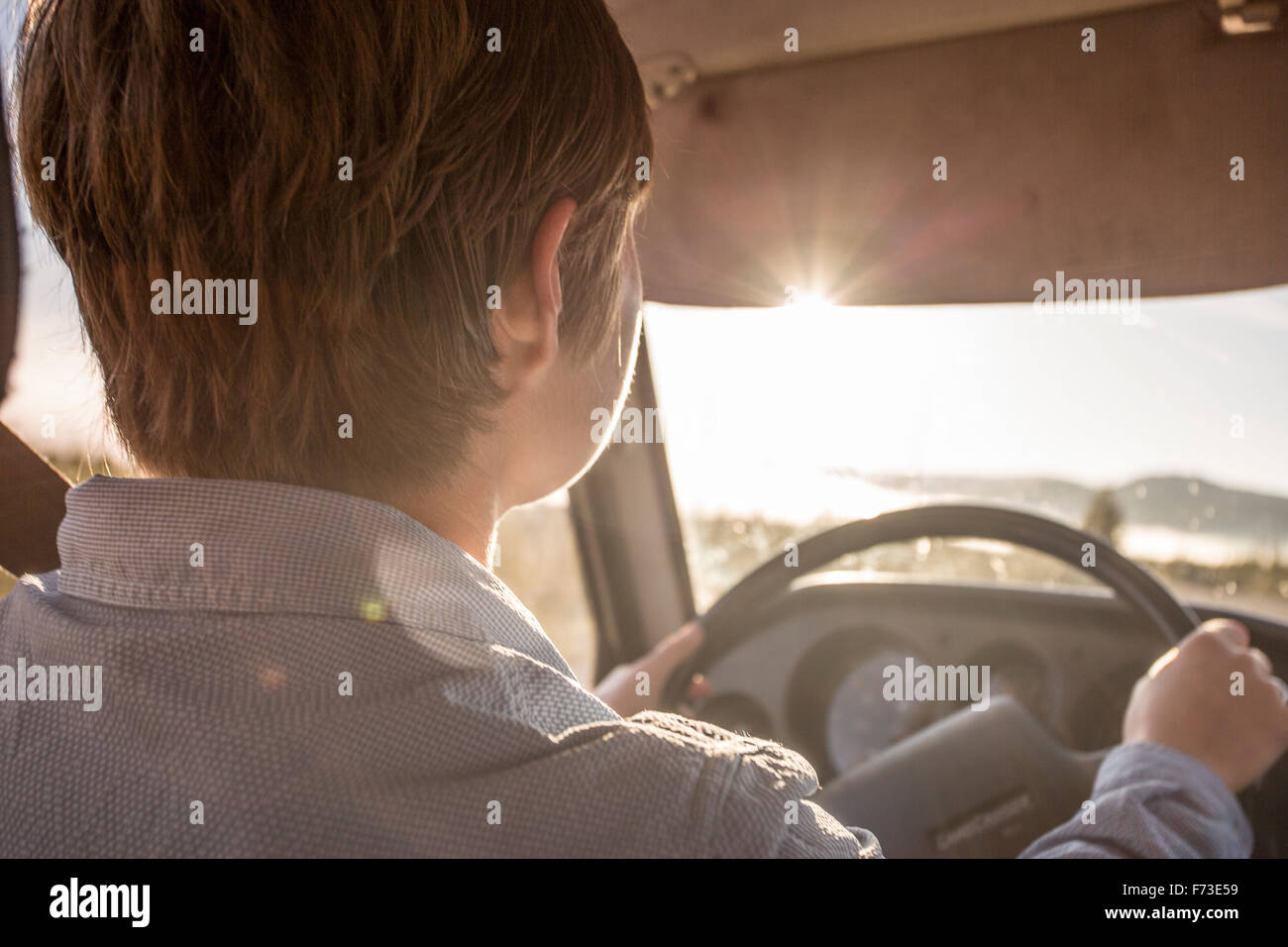 Un jeune pilote conduit un 1990 Toyota Land Cruiser dans la brillante lumière de l'aube. Banque D'Images