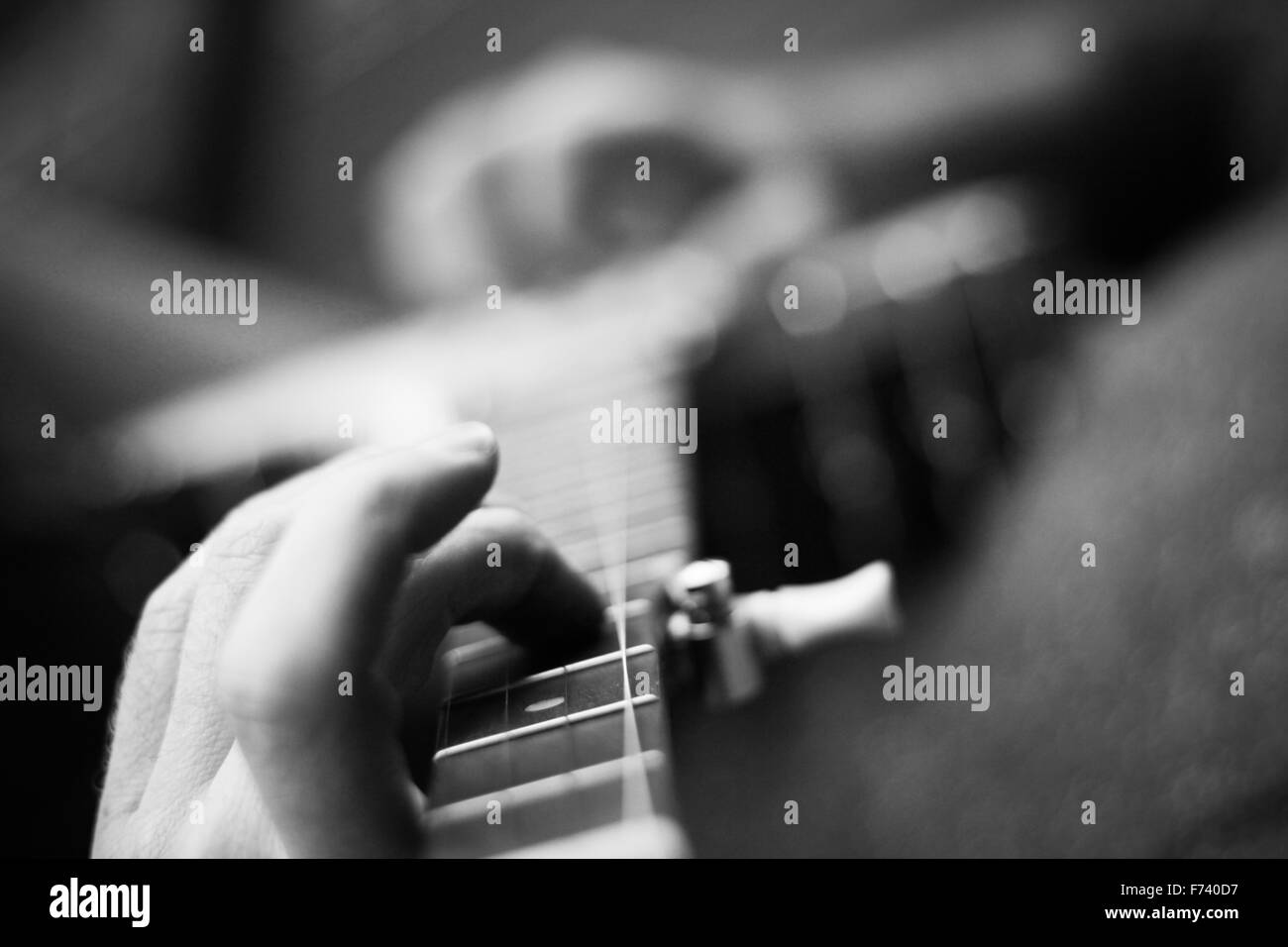 Image en noir et blanc d'un joueur de banjo mâle pratiquant certaines chansons folkloriques Banque D'Images