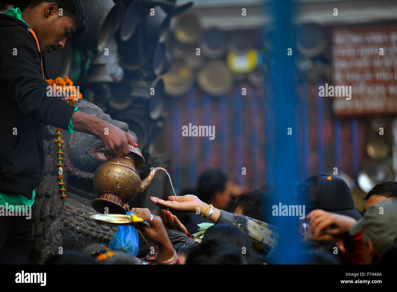 Katmandou, Népal. 25Th Nov, 2015. Un prêtre local offrant de l'eau bénite pour les dévots le dernier jour de 'Adinath Mela' Festival à Chovar. Dans le mois d'octobre ou novembre de Kojagrat purnima de Kartik purnima, personnes visitent Adinath temple le matin et effectuer de rituels puja et fonction rituelle lors d'Adinath Mela. © Narayan Maharjan/Pacific Press/Alamy Live News Banque D'Images