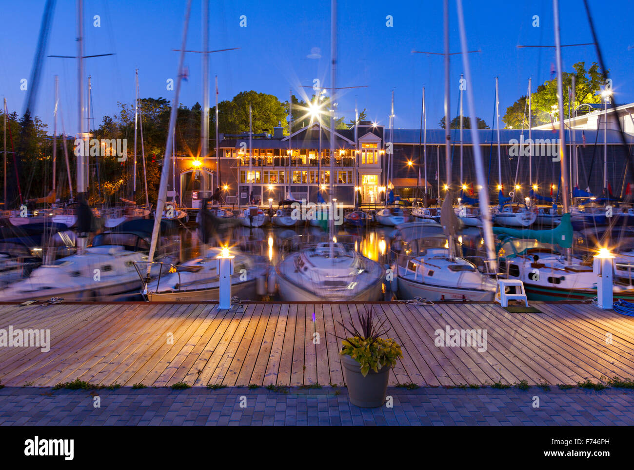Voiliers au port d'Oakville au crépuscule avec le Club d'Oakville dans l'arrière-plan. Shipyard Park, Oakville, Ontario, Canada. Banque D'Images