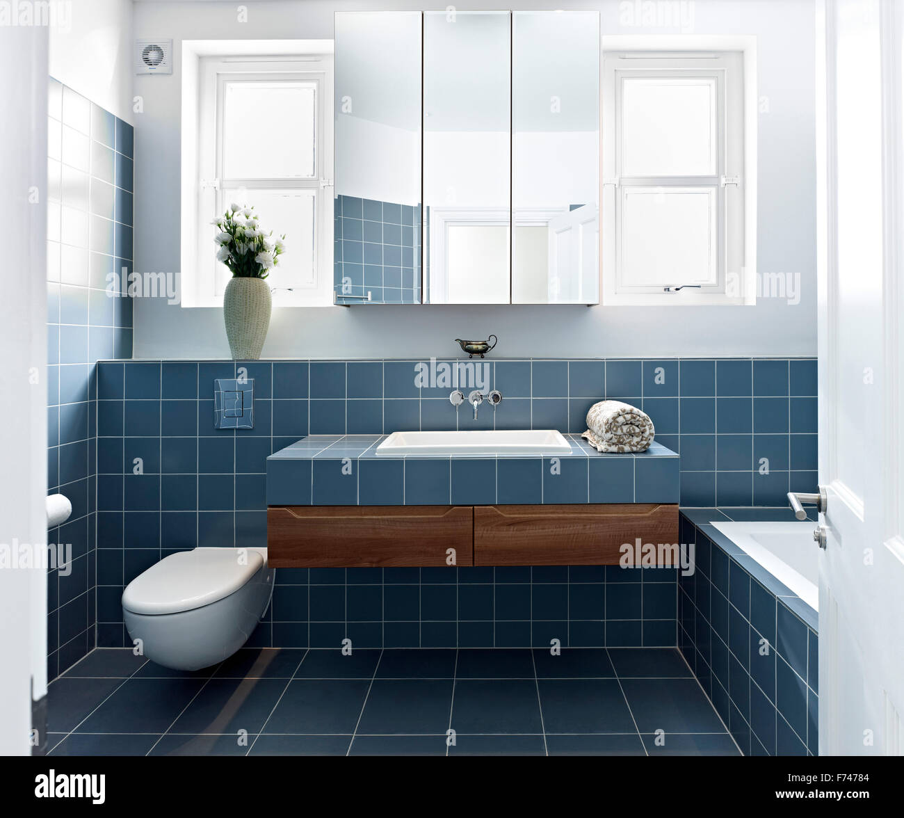 Salle de bains carrelée avec cabinet en miroir à Wolverton Jardins, 75015 West London, England, UK Banque D'Images