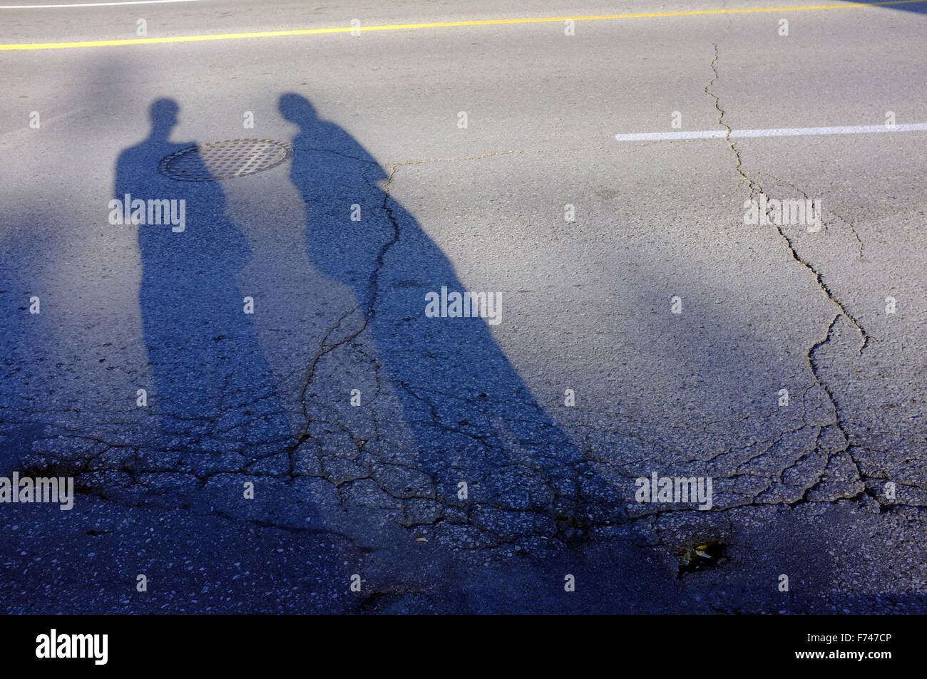 Les grandes ombres de deux personnes qui s'étend sur une route. Banque D'Images